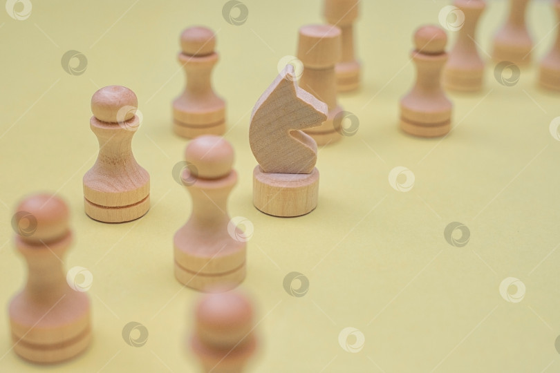 Скачать Шахматные фигуры крупным планом стоят в ряд на желтом фоне. Белые фигуры разных обозначений. Настольная игра. фотосток Ozero