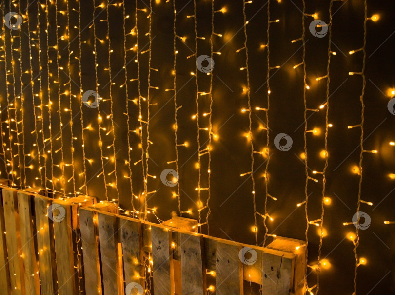 Скачать Рождественская гирлянда, золотые огоньки праздничной гирлянды сверкают на фоне стены, винтажная электрическая гирлянда. фотосток Ozero