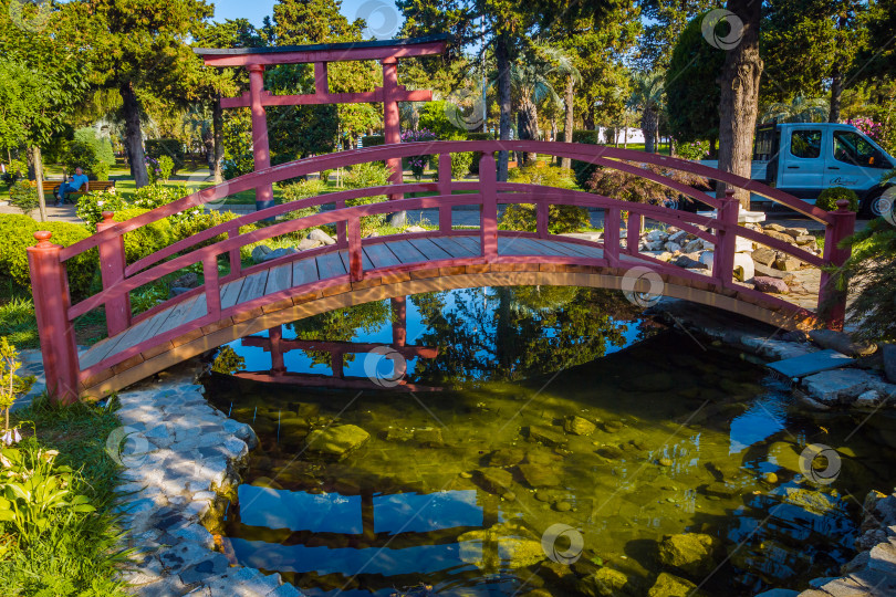 Скачать Батуми, Грузия - 10 июля 2019 года. Красный деревянный мост в Японском саду на бульваре. фотосток Ozero