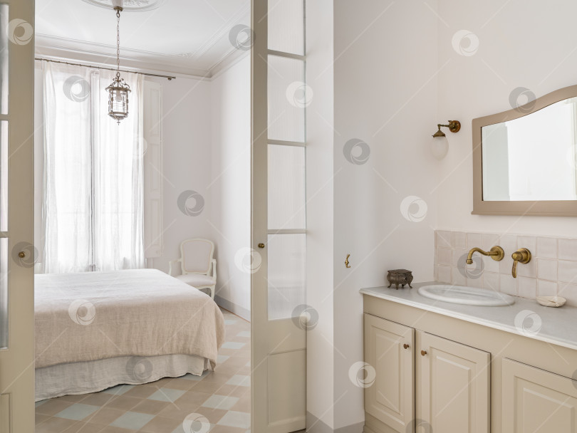 Скачать Светлый интерьер ванной комнаты с видом на спальню, оформленной в винтажном стиле. фотосток Ozero