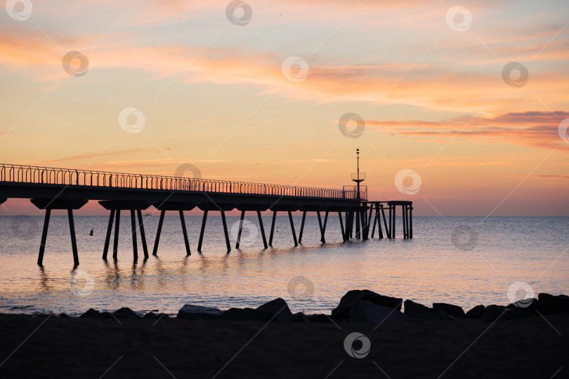 Скачать Восход солнца в Средиземном море с видом на понтон и пляж - Понт дель Петроли, Бадалона, Барселона, Каталония, Испания фотосток Ozero