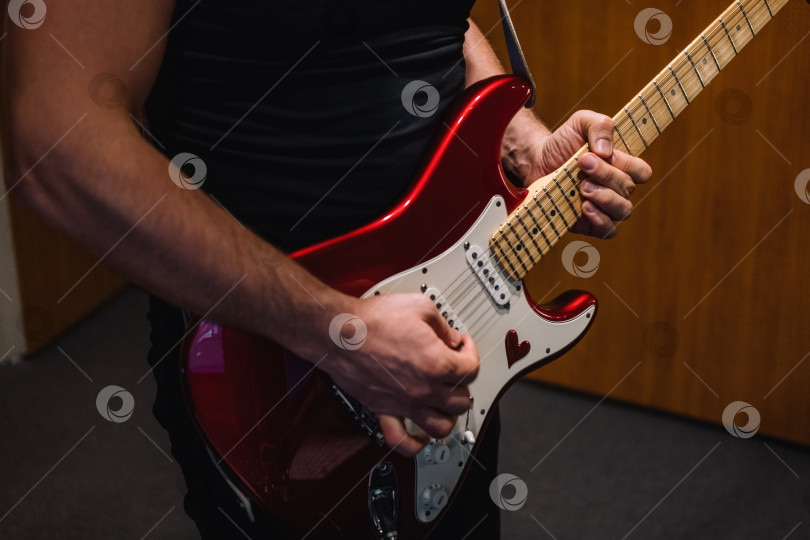 Скачать Повторение выступления рок-группы в студии. Обрезанное изображение игрока на электрогитаре. фотосток Ozero