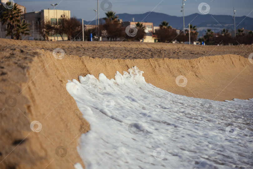 Скачать Пенная морская волна на остром краю песчаного пляжа на закате. Избирательный фокус. фотосток Ozero