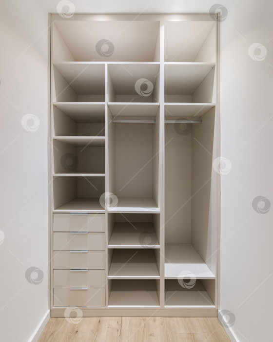 Скачать Новая встроенная мебель в небольшой гардеробной комнате. Современная кладовая со шкафом для одежды, множеством полок и выдвижных ящиков фотосток Ozero