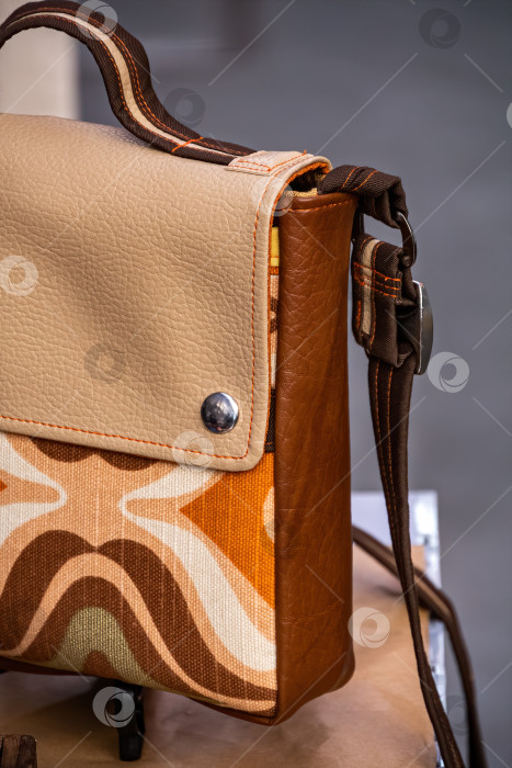 Скачать Женская кожаная сумочка ручной работы коричневого, оранжевого и бежевого цветов. Концепция моды и ремесла. фотосток Ozero