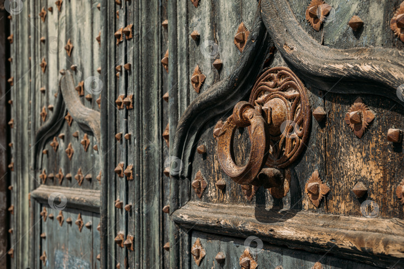 Скачать Подробная информация о портале в собор. Металлический молоток на старых деревянных дверях, укрепленных кованым железом, в кафедральном соборе Жироны, Испания фотосток Ozero