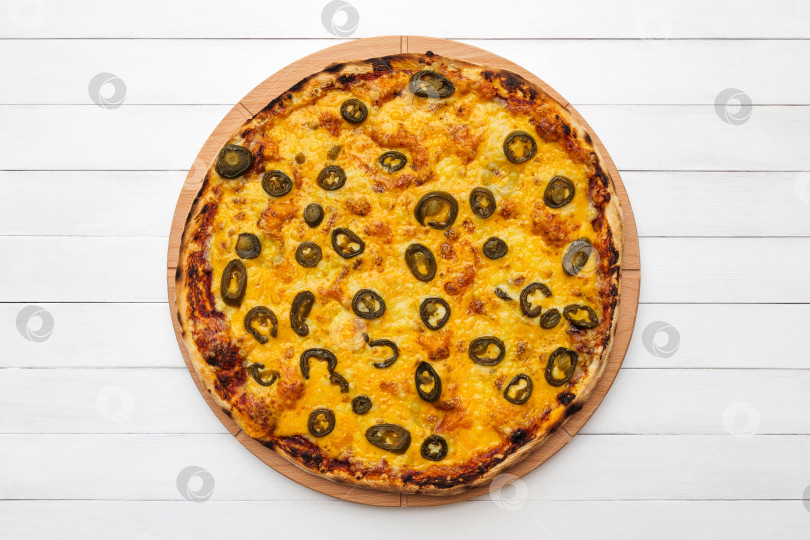 Скачать Цельнокруглая пицца с оливками и сыром на деревянной тарелке. Вид сверху на фоне белой доски фотосток Ozero