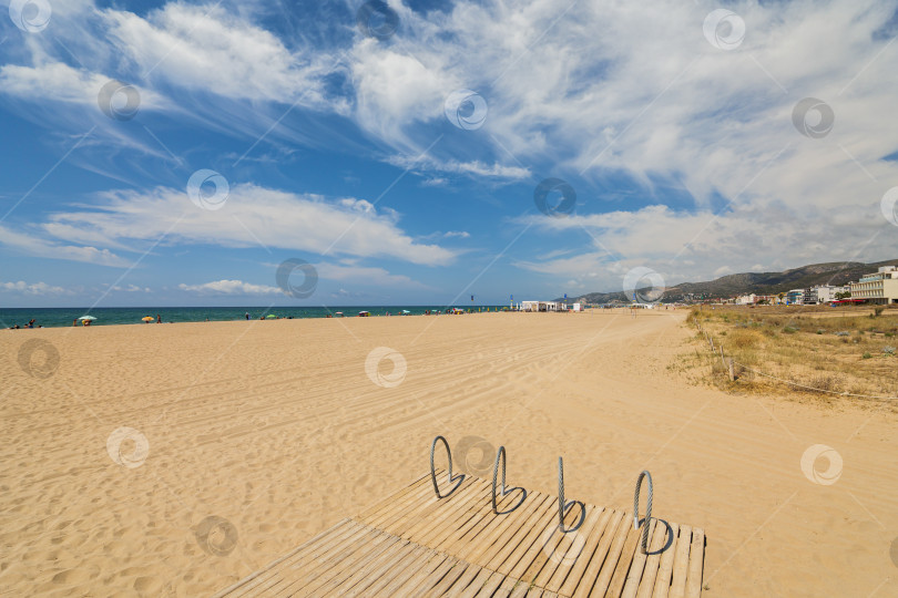Скачать Пляж Кастельдефельс с песчаными дюнами и стоянкой для велосипедов. Солнечный день с голубым морем и небом. фотосток Ozero