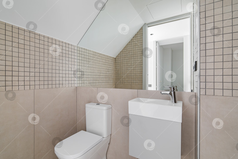 Скачать Интерьер современной ванной комнаты с бежевой плиткой, туалетом и небольшой раковиной фотосток Ozero