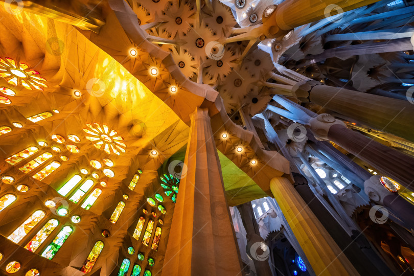 Скачать БАРСЕЛОНА, ИСПАНИЯ - 3 марта 2019 года: Красочный интерьер храма Святого Семейства. Собор, спроектированный Гауди. фотосток Ozero