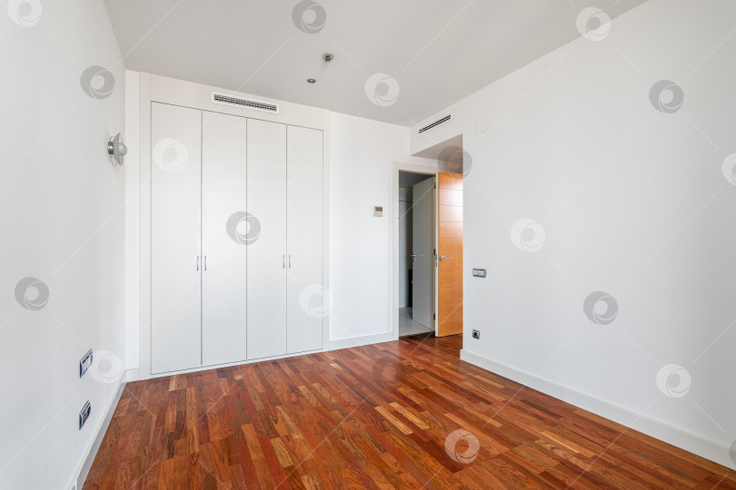Скачать Интерьер пустой квартиры, белая комната со встроенным шкафом и паркетным полом фотосток Ozero