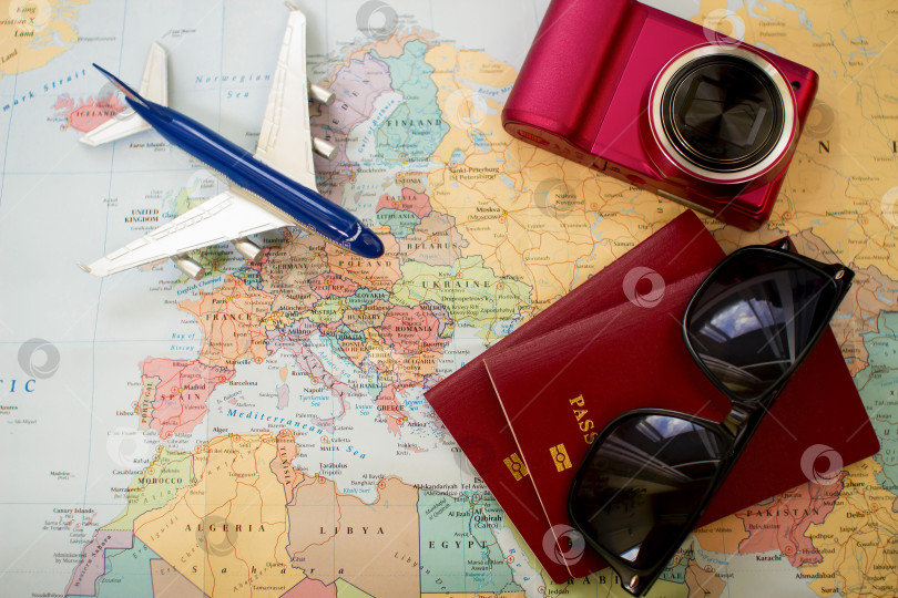 Скачать концепция путешествия, два паспорта, очки, фотоаппарат и игрушечный самолет на карте фотосток Ozero