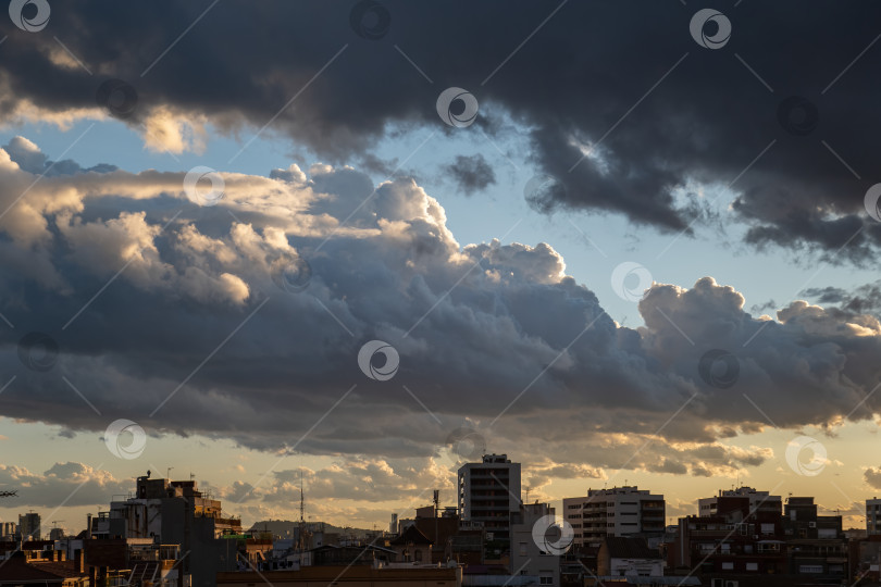 Скачать Впечатляющее небо в закатных сумерках над городом с тяжелыми облаками фотосток Ozero