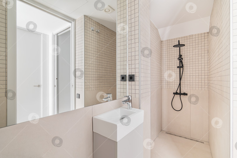Скачать Интерьер современной ванной комнаты с бежевой плиткой, душем и небольшой раковиной фотосток Ozero