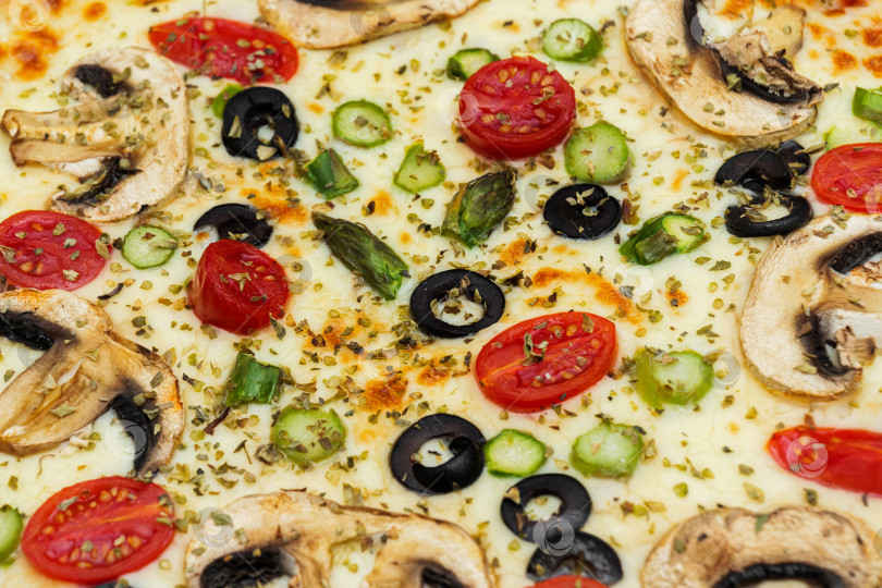 Скачать Крупный план вегетарианской пиццы с грибами, сыром, маслинами и помидорами черри. фотосток Ozero