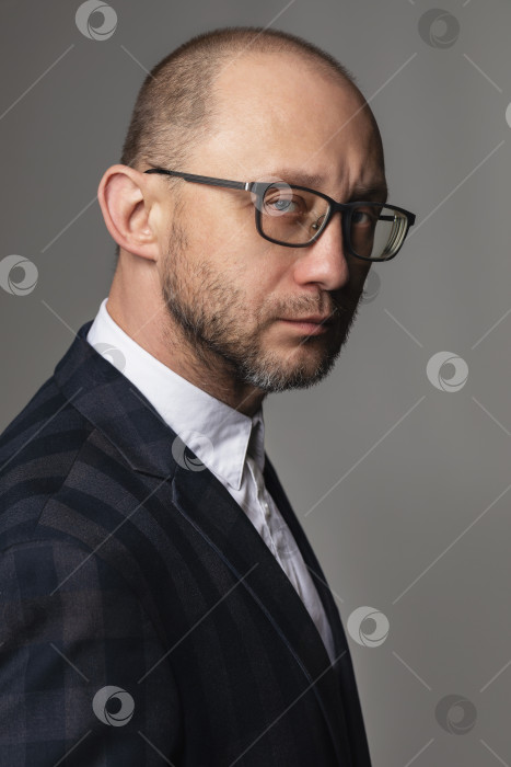 Скачать Портрет мужчины с задумчивым взглядом в костюме и очках фотосток Ozero