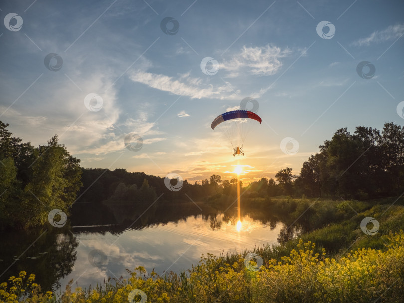 Скачать Экстремальные виды спорта. Приводимый в действие парашют вечером на фоне голубого неба фотосток Ozero