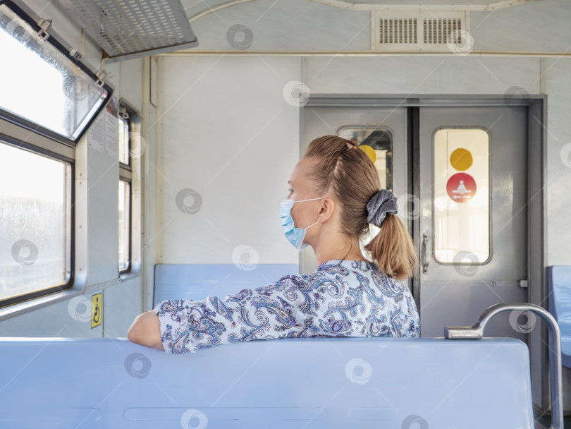 Скачать Женщина в маске в поезде. Безопасность в общественном месте во время эпидемии covid-19 фотосток Ozero