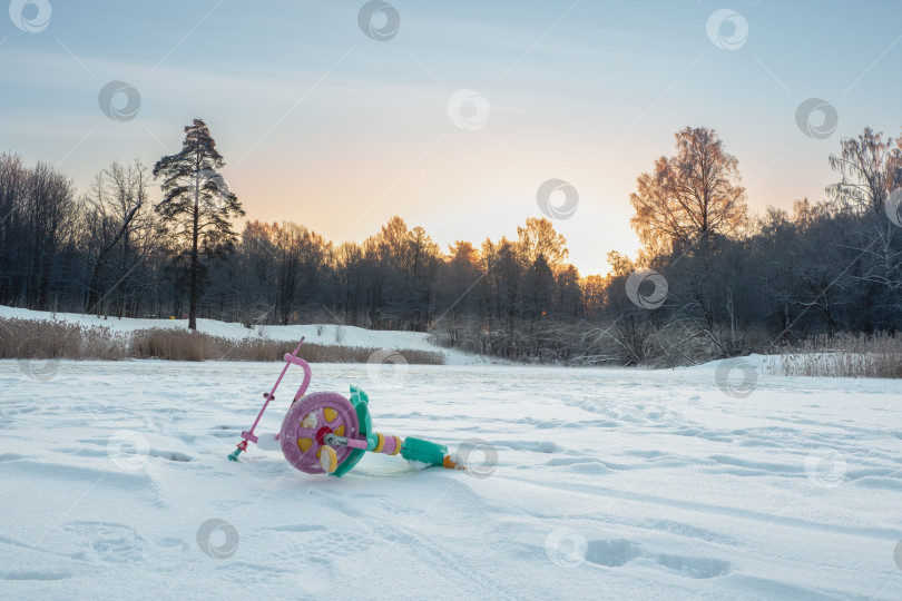 Скачать Брошенный сломанный детский велосипед в снегу. Концепция окончания каникул. фотосток Ozero
