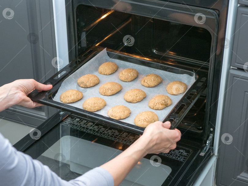 Скачать Повар печет печенье в духовке на кухне. Выпечка песочного теста фотосток Ozero