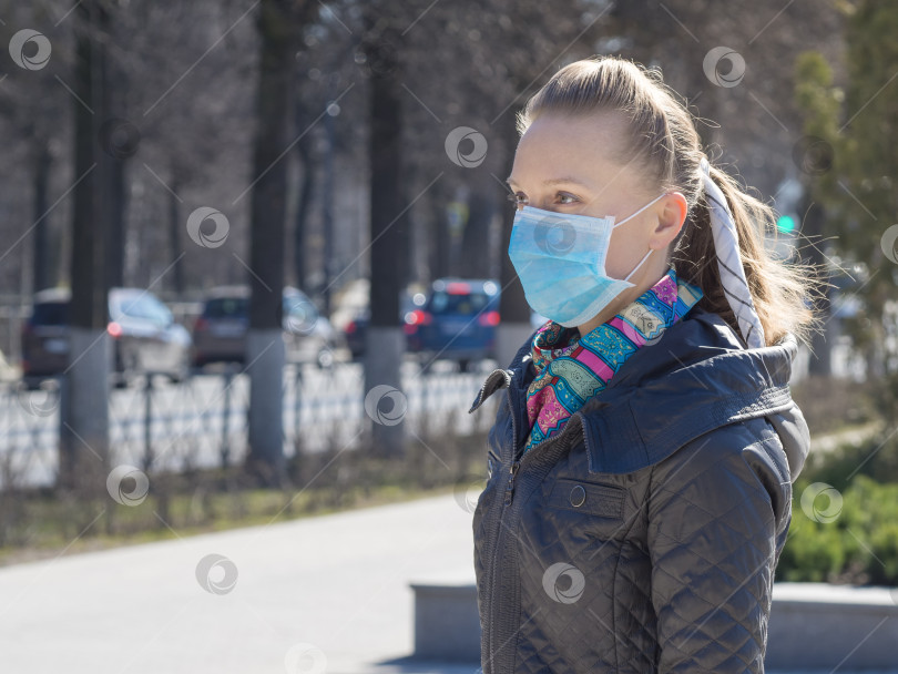 Скачать Женщина в медицинской маске на улице в городе фотосток Ozero