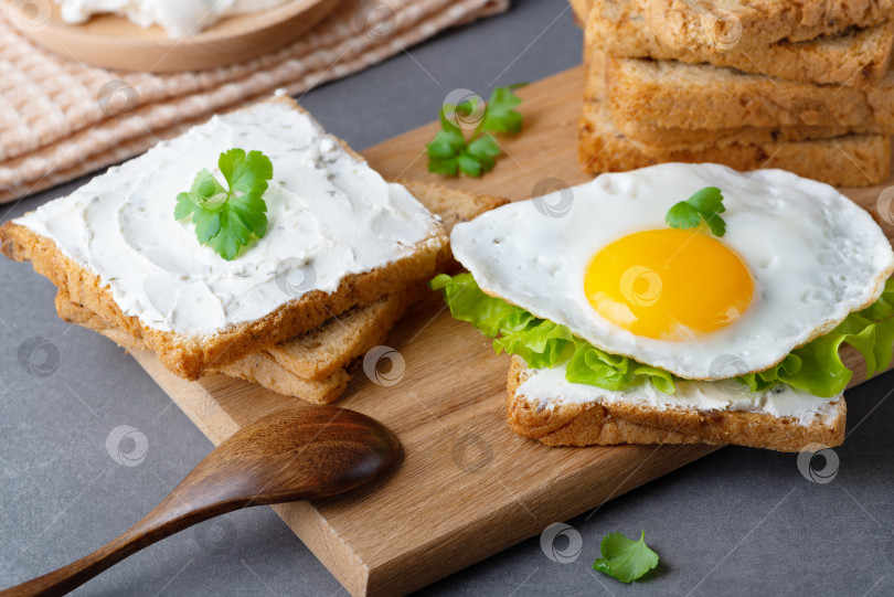 Скачать Бутерброды с творожным сыром, жареным яйцом и зеленью фотосток Ozero