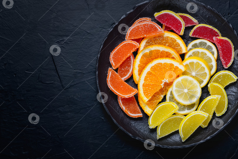 Скачать Разноцветные мармеладно-желейные конфеты и кусочки апельсина и лимона. Десертный мармелад в виде ломтиков лимона и апельсина фотосток Ozero