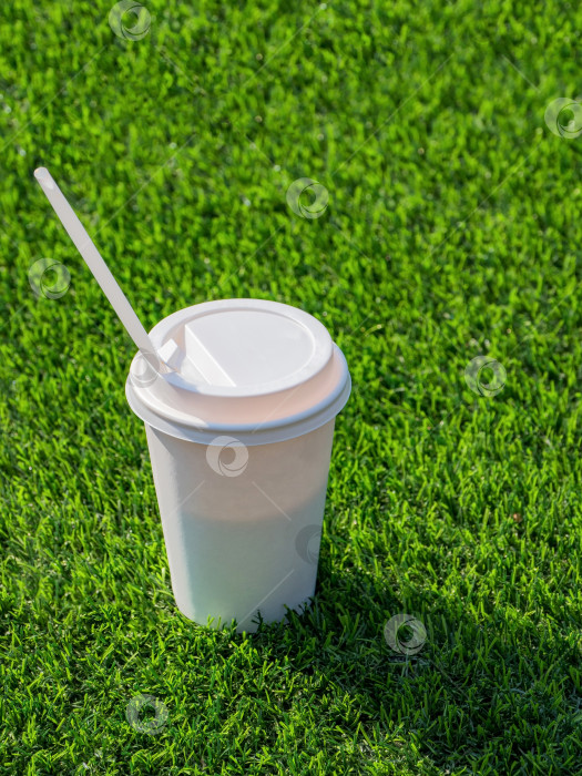 Скачать Пейте в бумажном стаканчике с соломинками для питья на футбольном поле. фотосток Ozero