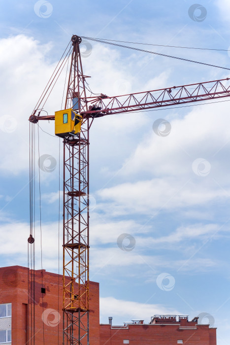 Скачать Башенный строительный кран на фоне строящегося кирпичного дома фотосток Ozero