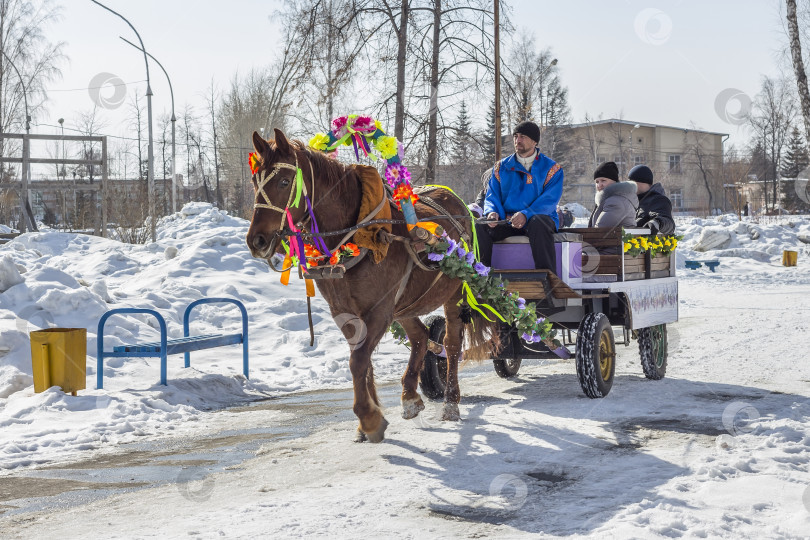 Скачать Лошадь, запряженная в телегу, везет людей на русский праздник Масленицу фотосток Ozero