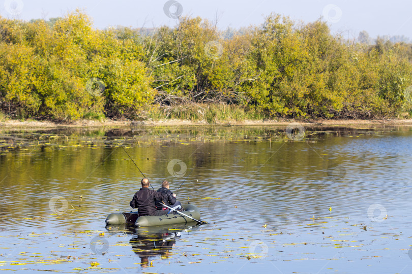 Скачать Рыбаки гребут на надувной лодке, чтобы поймать хищную рыбу фотосток Ozero