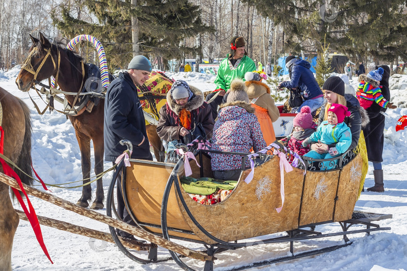 Скачать Лошадь, запряженная в телегу, везет людей на русский праздник Масленицу фотосток Ozero