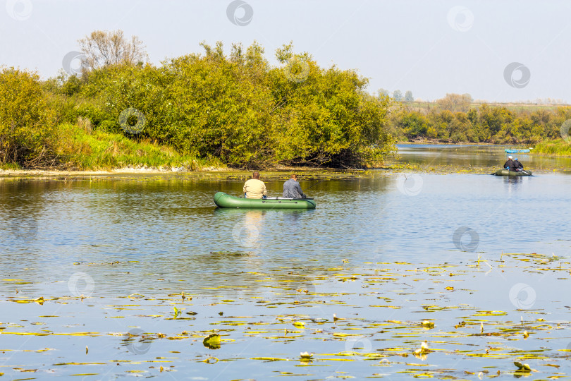 Скачать Рыбаки гребут на надувной лодке, чтобы поймать хищную рыбу фотосток Ozero