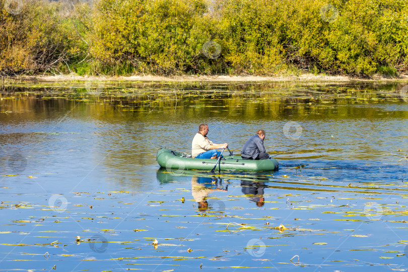 Скачать Рыбаки гребут на надувной лодке, чтобы поймать хищную рыбу фотосток Ozero