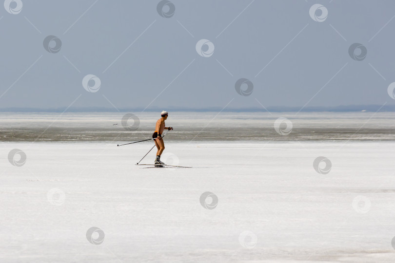 Скачать Лыжник без рубашки бежит по замерзшему льду Обского водохранилища фотосток Ozero