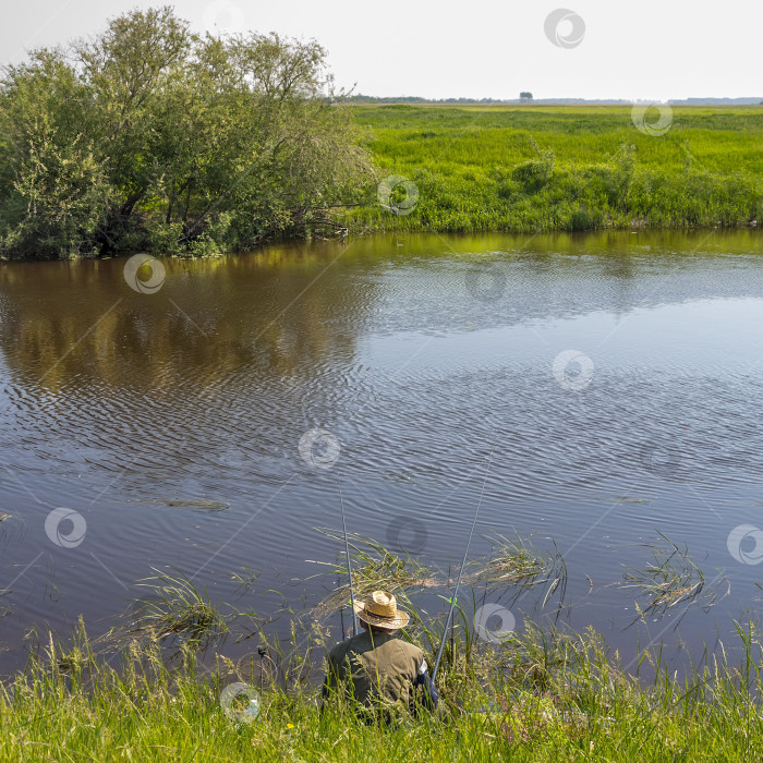 Скачать Рыбак летним днем ловит рыбу на реке на поплавке фотосток Ozero