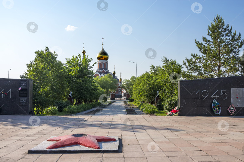 Скачать Мемориал и аллея славы городу Каргат, погибшему во время Второй мировой войны 1941-1945 годов, на фоне православной церкви фотосток Ozero