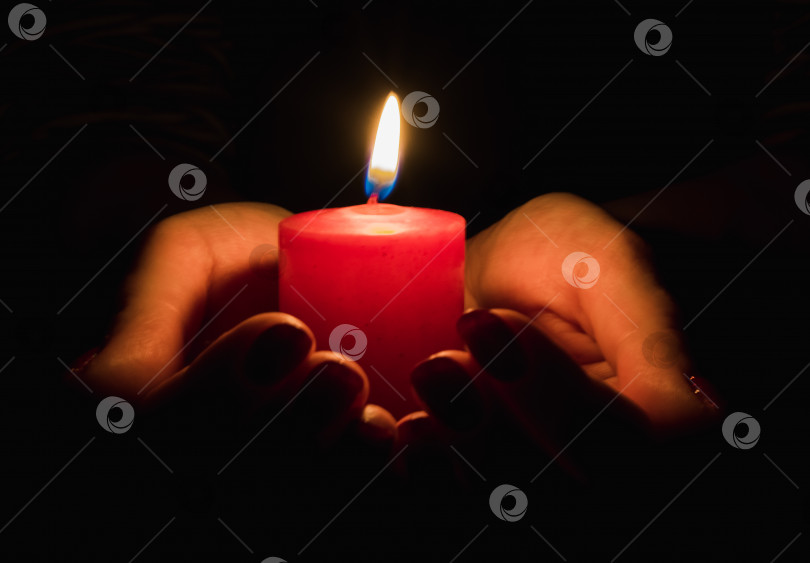 Скачать Женские руки, держащие горящую свечу в темноте фотосток Ozero