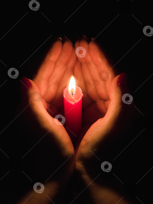 Скачать Женские руки, держащие горящую свечу в темноте фотосток Ozero