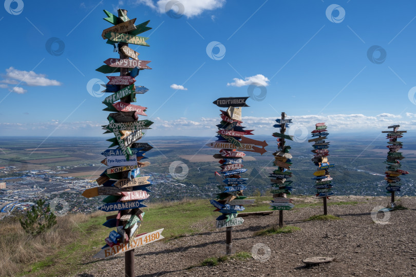 Скачать Столбы с указателями расстояний до различных городов России и мира на вершине горы Машук фотосток Ozero