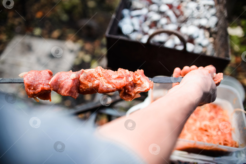 Скачать Мужчина готовит шашлык крупным планом. Сочное мясо на гриле на шампуре фотосток Ozero