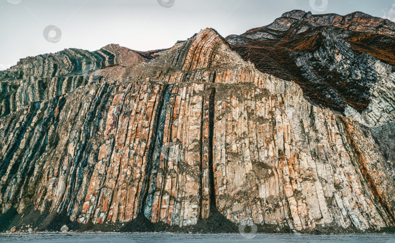 Скачать Цветные слои камней в разрезе горы, различные скальные образования и слои почвы. фотосток Ozero