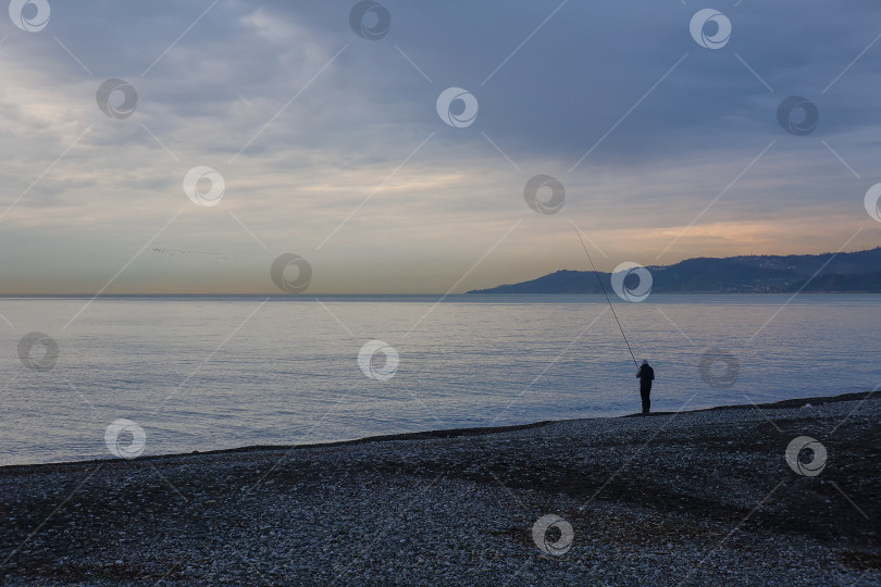 Скачать Рыбак на рассвете у моря фотосток Ozero