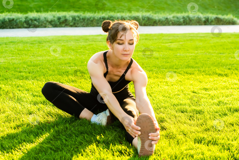 Скачать женщина занимается спортом в парке и улыбается. лето, солнце, здоровье, фитнес, растяжка. спорт на открытом воздухе. фотосток Ozero