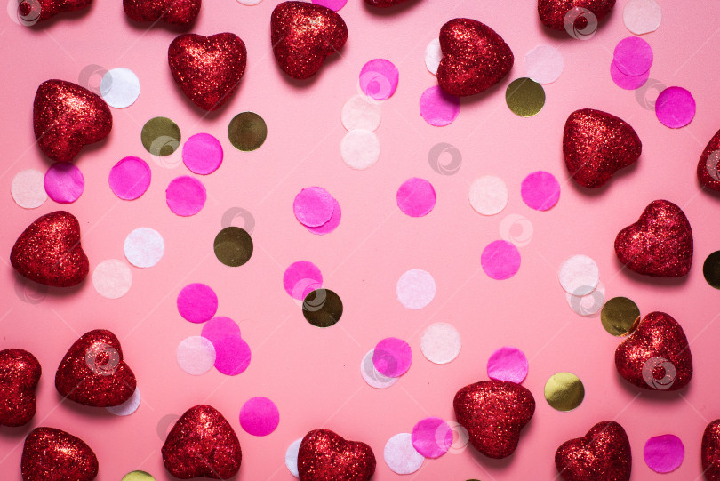Скачать рамка. пустая открытка на день святого Валентина. на розовом фоне конфетти и красные сердечки. забавные поздравления. Плоское положение, вид сверху. красные блестящие сердечки фотосток Ozero