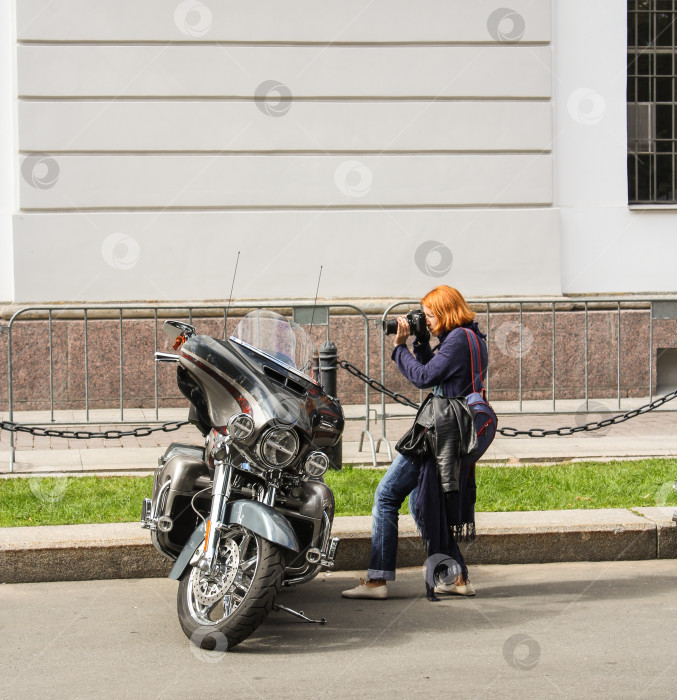 Скачать Женщина фотографирует мотоцикл. фотосток Ozero