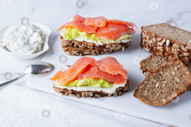 Скачать Полезные тосты из ржаного хлеба со сливочным сыром, лососем и салатом фотосток Ozero