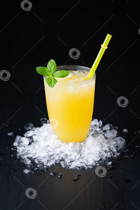 Скачать Стакан свежевыжатого апельсинового сока со льдом на черном фоне с местом для надписи фотосток Ozero