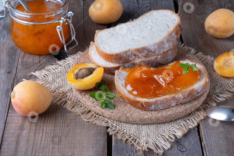 Скачать Тосты из хлеба с абрикосовым джемом и свежими фруктами с мятой на старом деревянном столе. Вкусный завтрак фотосток Ozero