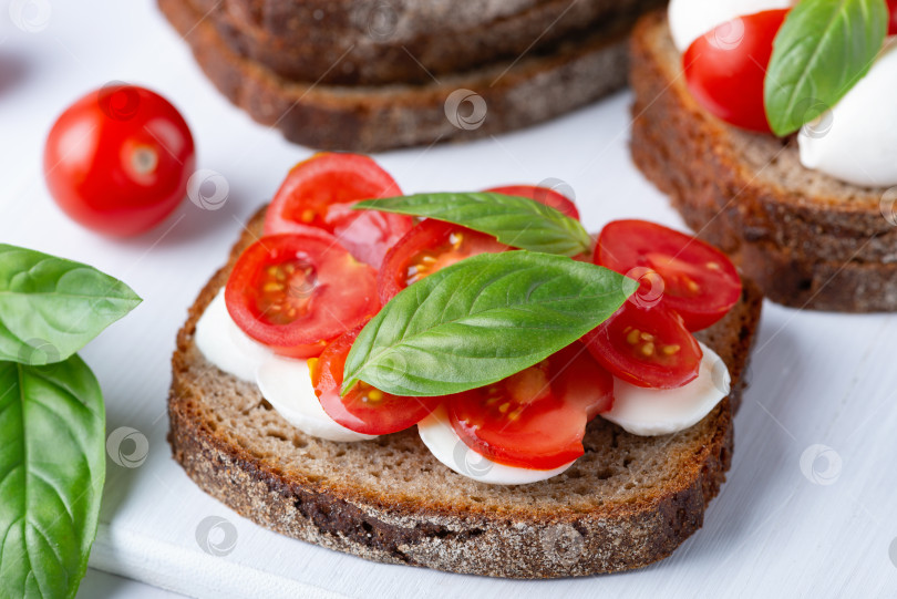 Скачать Вкусный сэндвич с моцареллой, свежими помидорами и базиликом фотосток Ozero